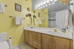 Full bathroom with vanity, light tile patterned floors, and a shower