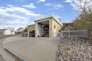 View of outbuilding with driveway and a gate