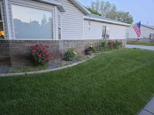 View of front of home featuring a yard and brick siding
