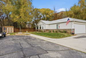 View of front of home with brick siding, driveway, a mountain view, and an attached garage