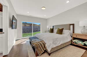 Bedroom with wood finished floors, access to exterior, and recessed lighting
