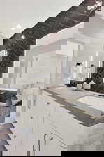 Ensuite bathroom featuring double vanity and backsplash