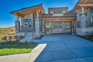 View of front of property with stone siding and driveway