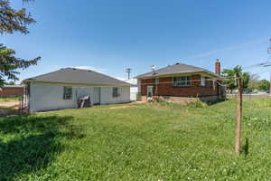 Back of property with brick siding and a chimney