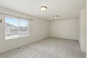 Empty room with light carpet and baseboards