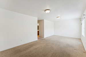 Unfurnished room with light carpet and baseboards