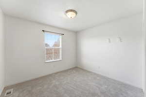 Spare room with light carpet and baseboards