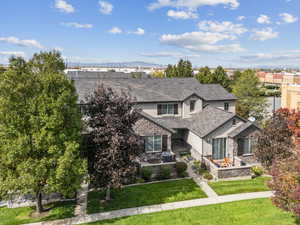 View of front of home featuring stucco siding, a front lawn, an outdoor fire pit, stone siding, and a mountain view