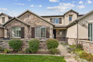 View of front of property with stone siding and stucco siding