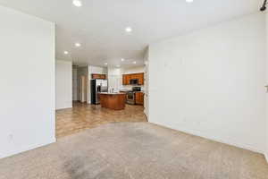 Unfurnished living room featuring recessed lighting and light carpet