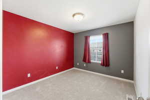 Unfurnished room with carpet flooring and an accent wall