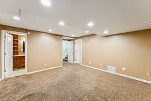 Finished basement featuring recessed lighting, light carpet, and stairs
