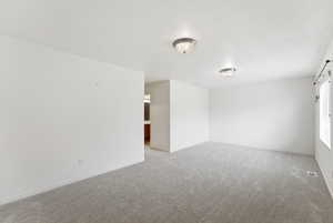 Empty room featuring carpet flooring and baseboards