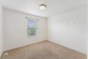 Carpeted empty room with baseboards