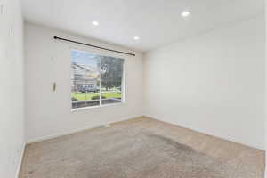 Carpeted empty room featuring recessed lighting and baseboards