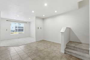 Entrance foyer with light carpet, recessed lighting, and light tile patterned flooring