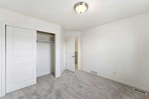 Unfurnished bedroom with light colored carpet and a closet