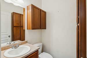 Half bathroom with vanity and toilet