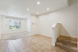 Unfurnished room featuring light tile patterned flooring, light carpet, and recessed lighting