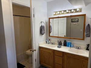 Bathroom featuring double vanity and light tile patterned flooring