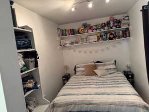 Bedroom with a textured ceiling and a closet