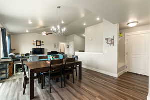 Dining area with lofted ceiling, wood finished floors, a chandelier, ceiling fan, and recessed lighting