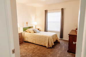Bedroom featuring carpet and baseboards