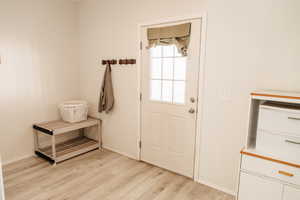 Doorway featuring wood finished floors and baseboards