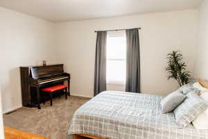 Bedroom featuring light carpet and baseboards