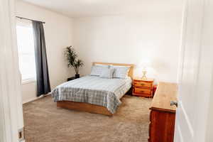 Bedroom featuring light carpet and baseboards