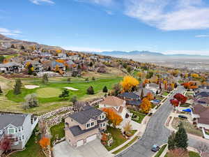 Aerial view of residential area with a mountainous background and a golf course