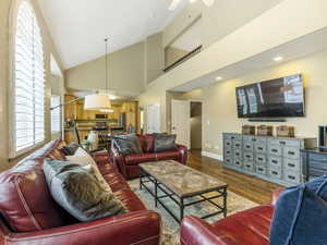 Living room featuring high vaulted ceiling, wood finished floors, and a ceiling fan