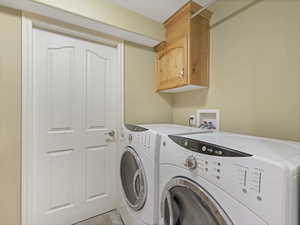 Additional basement laundry room with washing machine and dryer and cabinet space