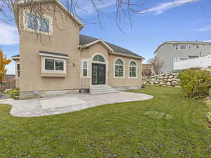 Back of property featuring a patio area and lawn