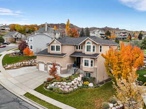 Traditional-style house with stucco and brick siding, three car garage and valley and mountain views