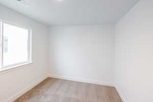 Spare room with light colored carpet and baseboards