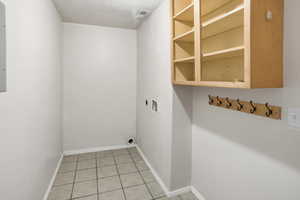 Laundry room with light tile, washer and dryer hookups