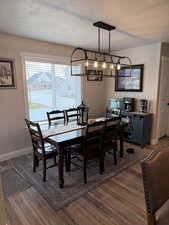 Dining area with a textured ceiling and dark wood-style floors