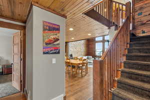 Stairway with wooden ceiling, wood finished floors, and recessed lighting