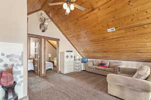 Carpeted living room with wood ceiling and vaulted ceiling