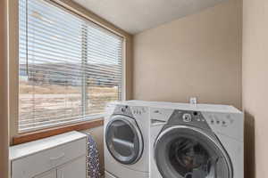 Laundry room with separate washer and dryer and a textured ceiling