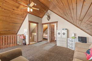 Living area with carpet floors, wood ceiling, lofted ceiling, and a ceiling fan