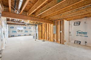 Basement featuring electric panel and heating unit