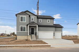 View of front of home with driveway and an attached garage
