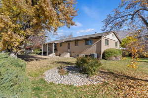 Rear view of property with brick siding and a lawn