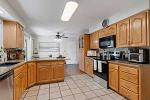 Kitchen with backsplash, a peninsula, appliances with stainless steel finishes, and light stone countertops