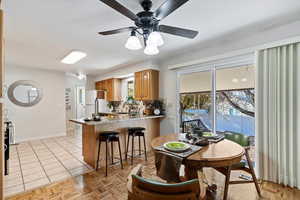 Dining area with plenty of natural light, a ceiling fan, and light tile patterned flooring