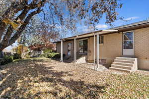 Back of property with brick siding and entry steps