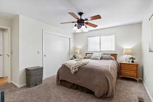 Bedroom with a closet, carpet, and a ceiling fan