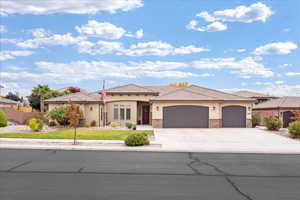 View of front of property with stucco siding, an attached garage, driveway, and a tiled roof